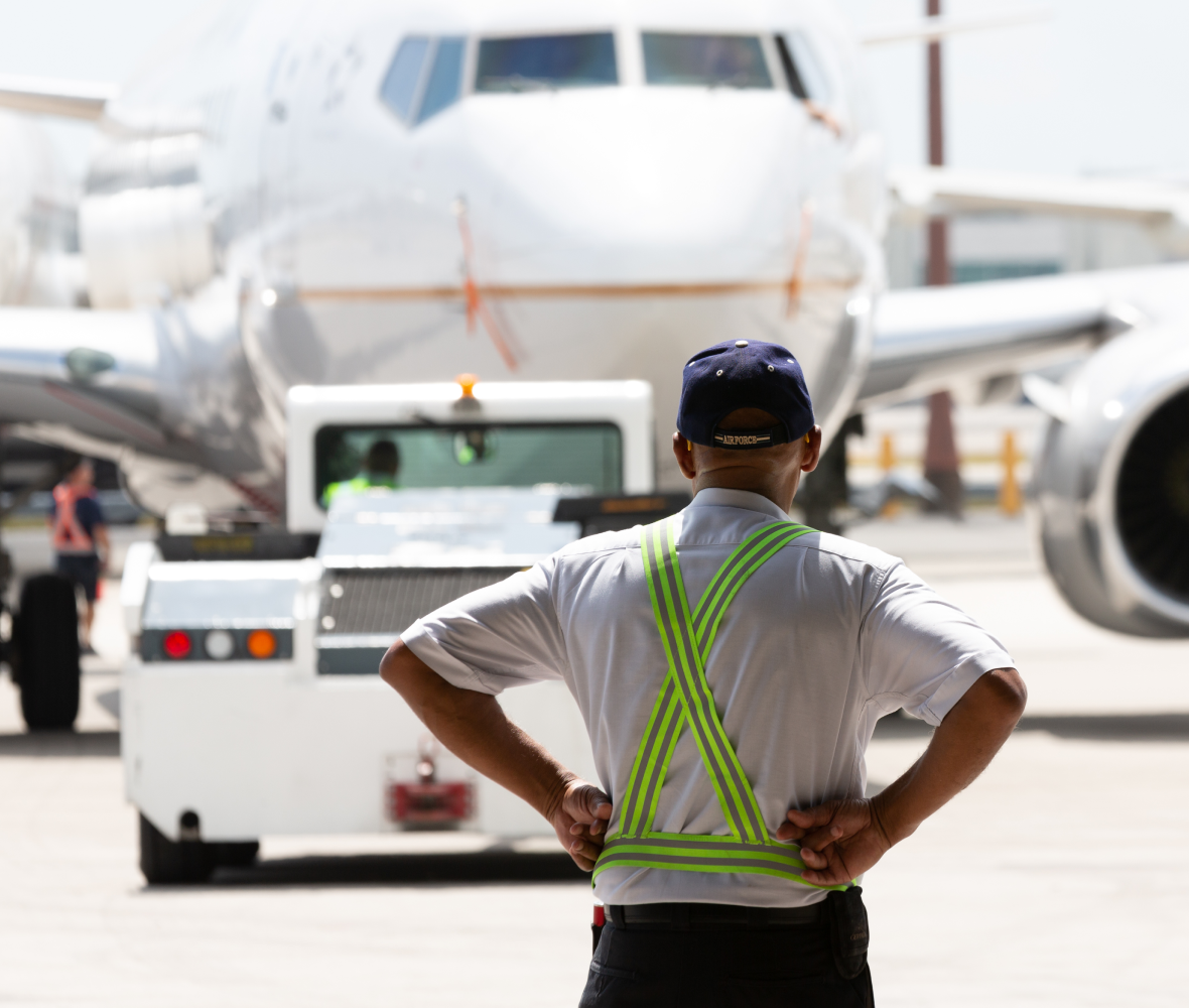 Person with arms on waist looking at an airplane Person with arms on waist looking at an airplane