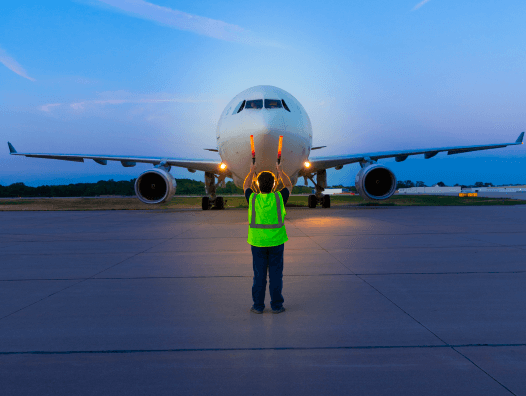 Employee directing an airplane on the runway Employee directing an airplane on the runway